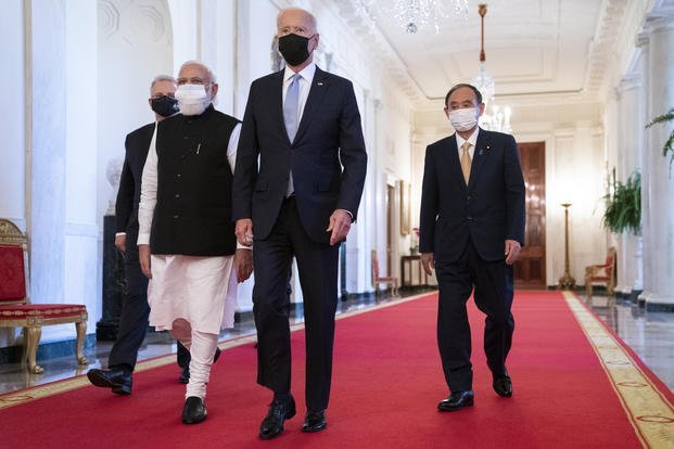 President Joe Biden walks to the Quad summit with, from left, Australian Prime Minister Scott Morrison, Indian Prime Minister Narendra Modi, and Japanese Prime Minister Yoshihide Suga, in the East Room of the White House, Friday, Sept. 24, 2021, in Washington.